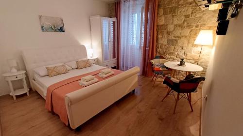 a bedroom with a white bed and a table and chairs at Split Old Town Suites in Split