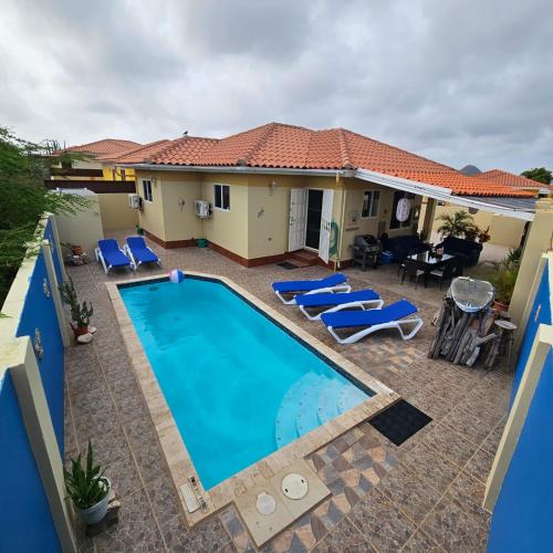 a villa with a swimming pool in front of a house at Cozy home under the Sun with Swimmingpool in Paradera
