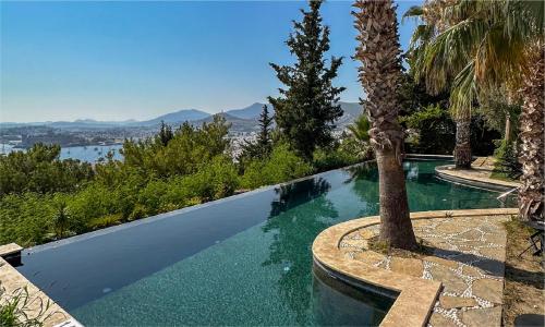 a swimming pool with a palm tree in the foreground at Manastir Hotel & Suites in Bodrum City