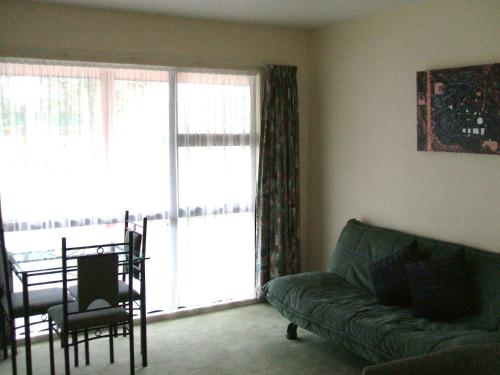 a living room with a couch and a large window at Pavilion Motel & Conference Centre in Palmerston North