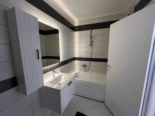 a bathroom with a sink and a bath tub at Skyline Serenity Apartment in Prizren