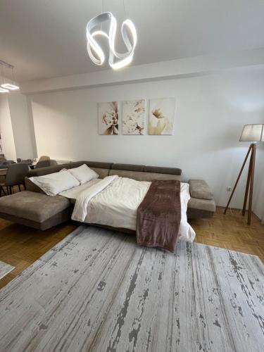 a bedroom with a bed and a couch at Skyline Serenity Apartment in Prizren