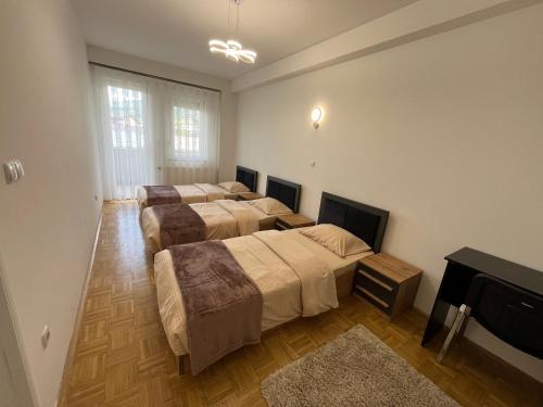 a room with three beds and a flat screen tv at Skyline Serenity Apartment in Prizren