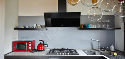 una cucina con piano cottura e forno a microonde rosso di B&B Audrey a Varese