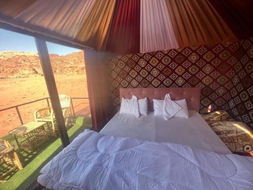 a bedroom with a bed and a view of the desert at Desert Bedouin adventure in Wadi Rum