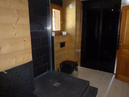 La salle de bains est pourvue d'une douche et d'un mur en carrelage noir. dans l'établissement Appartement Spacieux pour 9 Pers., Balcon Sud-Ouest, Wifi Inclus, Proche Pistes - Isola 2000 - FR-1-292-109, à Isola 2000