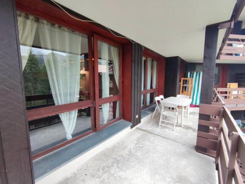 d'un balcon avec des fenêtres, une table et des chaises. dans l'établissement Appartement Spacieux pour 9 Pers., Balcon Sud-Ouest, Wifi Inclus, Proche Pistes - Isola 2000 - FR-1-292-109, à Isola 2000