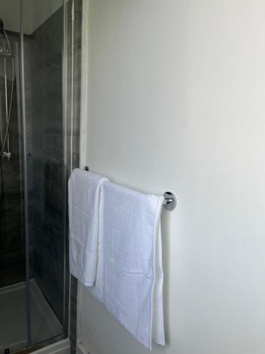 a bathroom with a towel hanging next to a shower at Stylish and Spacious Wi-Fi Smart TV Tea and coffee in Kettering