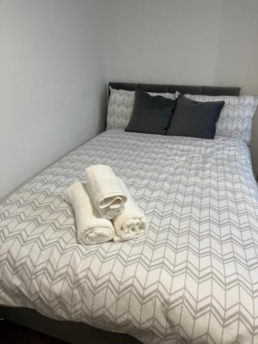 uma cama com duas toalhas em cima em Stylish and Spacious Wi-Fi Smart TV Tea and coffee em Kettering