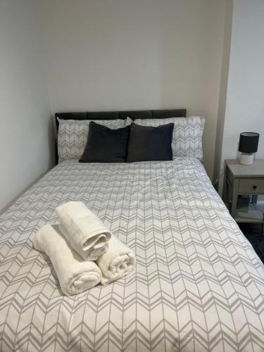a bed with towels and pillows on top of it at Stylish and Spacious Wi-Fi Smart TV Tea and coffee in Kettering