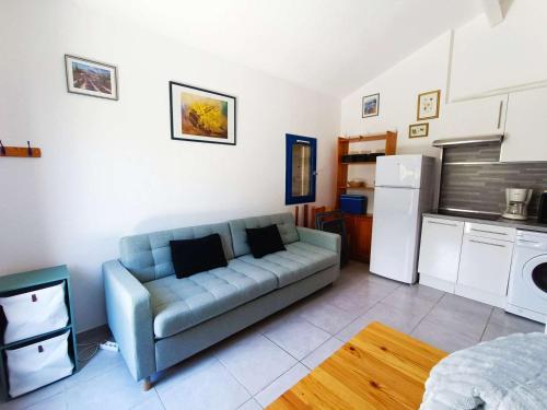 un salon avec un canapé et une cuisine dans l'établissement Mazet charmant au Lavandou avec piscine, proche plage et commodités - FR-1-308-85, au Lavandou