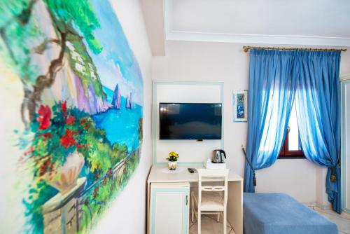B&B Il Pavone في كونكا دي ماريني: غرفة نوم مع مكتب ودهان على الحائط