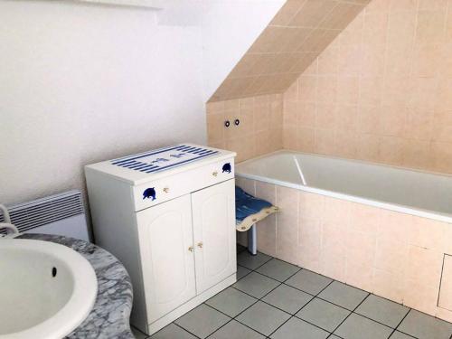 une salle de bain avec un lavabo et une baignoire dans l'établissement Appartement mansardé avec terrasse à 100m de la Plage St-Guirec, Ploumanac'h - FR-1-368-161, à Perros-Guirec