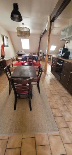 Mauves-sur-HuisneにあるF3 tout confort spacieuxの広いリビングルーム(テーブル、椅子付)