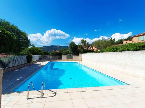 une piscine avec de l'eau bleue dans une cour arrière dans l'établissement Maison soignée avec grand jardin et terrasse - Le Lavandou - FR-1-308-159, au Lavandou
