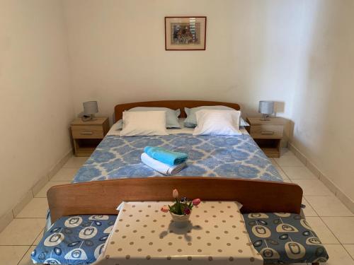 ein Schlafzimmer mit einem Bett und einem Tisch mit einem Topf darauf in der Unterkunft Captain's House in Baška Voda