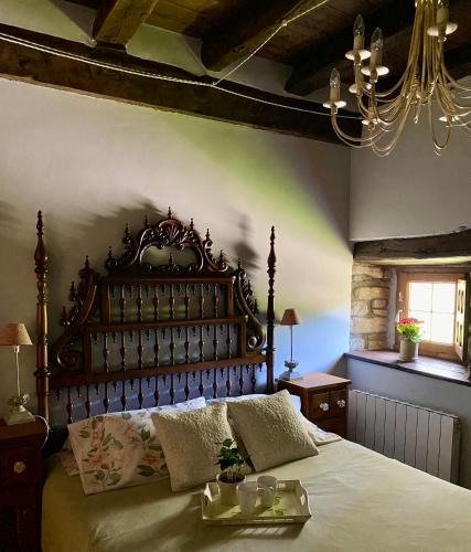 a bedroom with a large bed with a wooden headboard at Casa Mayor in Gordexola
