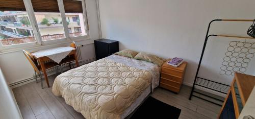 une chambre avec un lit, une table et une fenêtre dans l'établissement Chambre double privée, Appartement partagé, à Annemasse