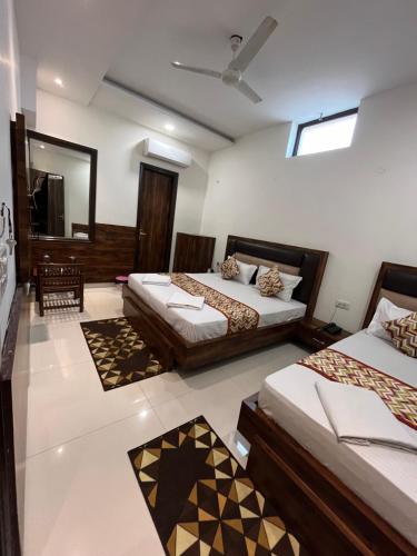 a hotel room with two beds and a mirror at Hotel SB Residency in Amritsar