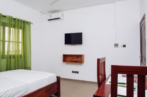1 dormitorio con 1 cama y TV en la pared en ORADYS RESIDENCE, 