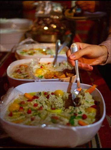 a person eating a bowl of food on a table at Desert Bedouin adventure in Wadi Rum