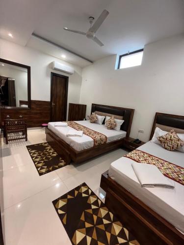 a bedroom with two beds and a mirror at Hotel SB Residency in Amritsar