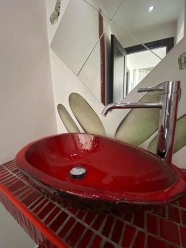 a red sink in a bathroom with a mirror at 5-Star feel - Luxury penthouse for 4 with huge balcony & view ,8 min from Athens airport in Koropíon