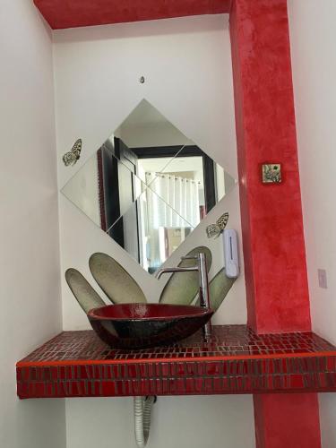 a mirror on a red shelf with a sink at 5-Star feel - Luxury penthouse for 4 with huge balcony & view ,8 min from Athens airport in Koropíon