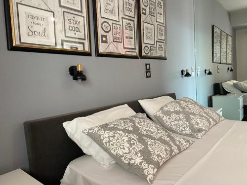 a bedroom with a bed with pillows on it at 5-Star feel - Luxury penthouse for 4 with huge balcony & view ,8 min from Athens airport in Koropíon