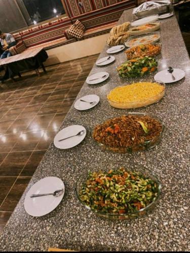 a table with plates and bowls of food on it at Desert Bedouin adventure in Wadi Rum