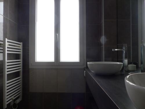 une salle de bain avec un lavabo blanc et une fenêtre dans l'établissement La Flotte Lumineuse maison de charme très calme, à La Flotte