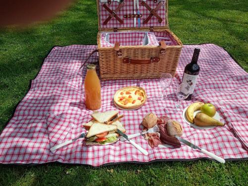 a picnic blanket with food and a bottle of wine at Le Vieux Noyer in Nassogne