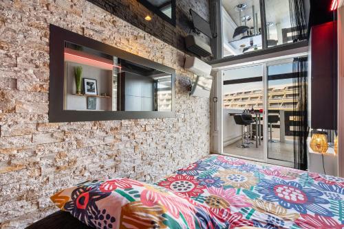 un lit dans une chambre avec un mur de briques dans l'établissement Shanel Port Nature coursive, au Cap d'Agde