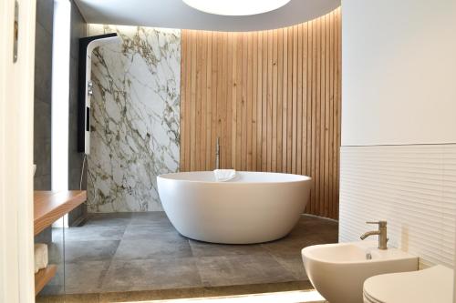 a bathroom with a white tub and a sink at Blumarea in Agropoli