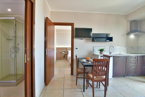 a kitchen with a table and a dining room at Hotel & Apartments Villa Linda in Giardini Naxos