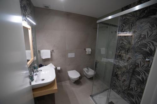 a bathroom with a shower and a toilet and a sink at Middle Town Palace in Tropea