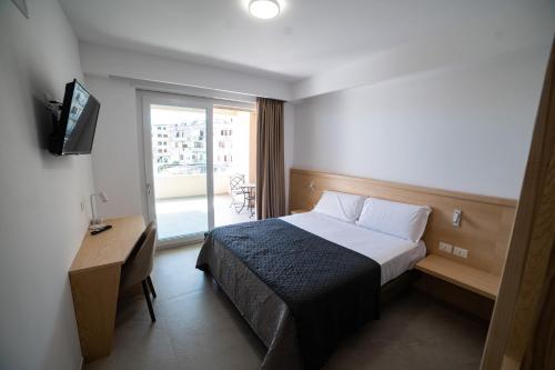 a hotel room with a bed and a desk and a window at Middle Town Palace in Tropea