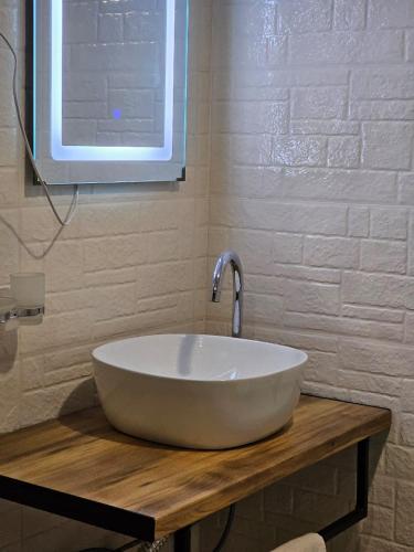 un lavabo blanc sur un comptoir en bois dans une salle de bain dans l'établissement LIME Shekvetili, à Shekvetili