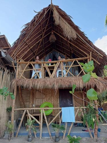 a thatched hut with two people in the window at 8 Star Paradise in Locaroc