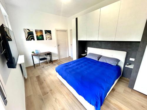 a bedroom with a large blue bed and a desk at Camera Matrimoniale in Casa Malpensa 501 in Samarate