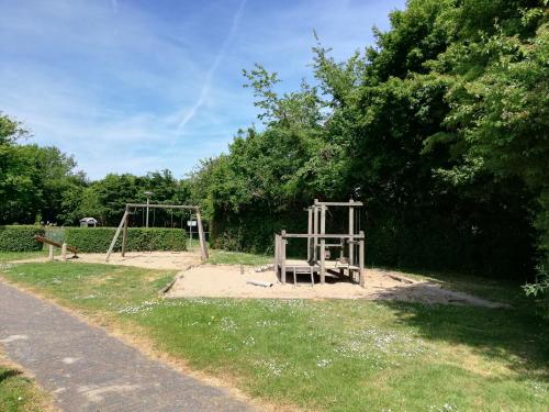 a park with a swing set in the grass at Rekerlanden 275 in Warmenhuizen