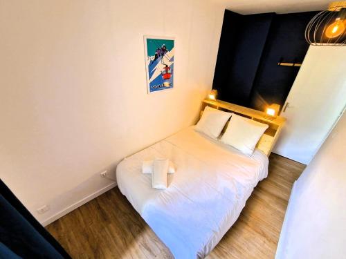 une petite chambre avec un lit avec deux oreillers dans l'établissement Appart Les Cosmiques, Vue Mont Blanc - Aiguille du Midi, à Chamonix-Mont-Blanc