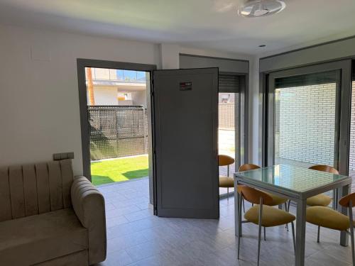 ein Wohnzimmer mit einem Glastisch und einer Couch in der Unterkunft Villa Rosa in Peñíscola