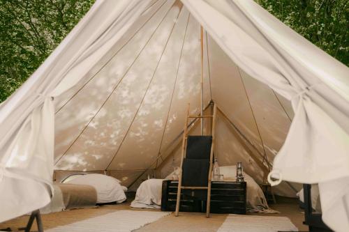 ein Zelt mit Betten und einem Stuhl darin in der Unterkunft Falkeröd - Lyxig glamping i naturreservat ink frukost in Grebbestad