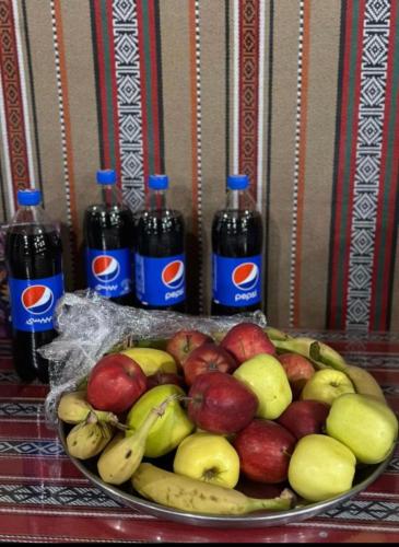 a plate of apples and bananas and bottles of soda at Desert Bedouin adventure in Wadi Rum