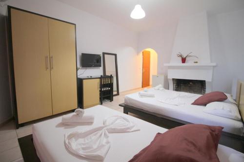 a hotel room with two beds and a fireplace at Hotel Ceka in Sarandë