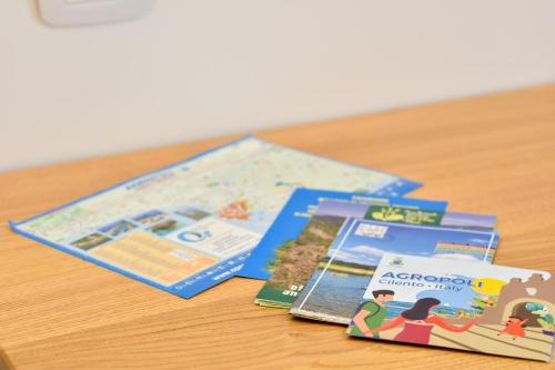 three magazines sitting on top of a wooden table at Blumarea in Agropoli
