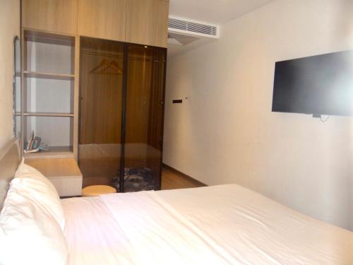 a bedroom with a bed and a flat screen tv at Kings House Apec Condotel Phú Yên in Tuy Hoa