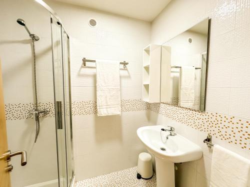 Un baño blanco con lavabo y ducha. en Apartamento Pindo B3 by ALÔGA, en O Pindo