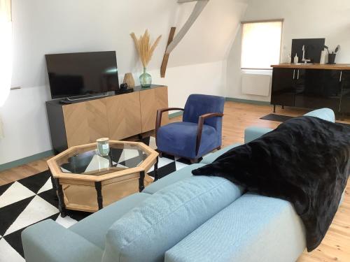 un salon avec un canapé bleu et une télévision dans l'établissement L’appart, à Bondues